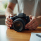Personne déballant un appareil photo neuf sur un bureau lumineux